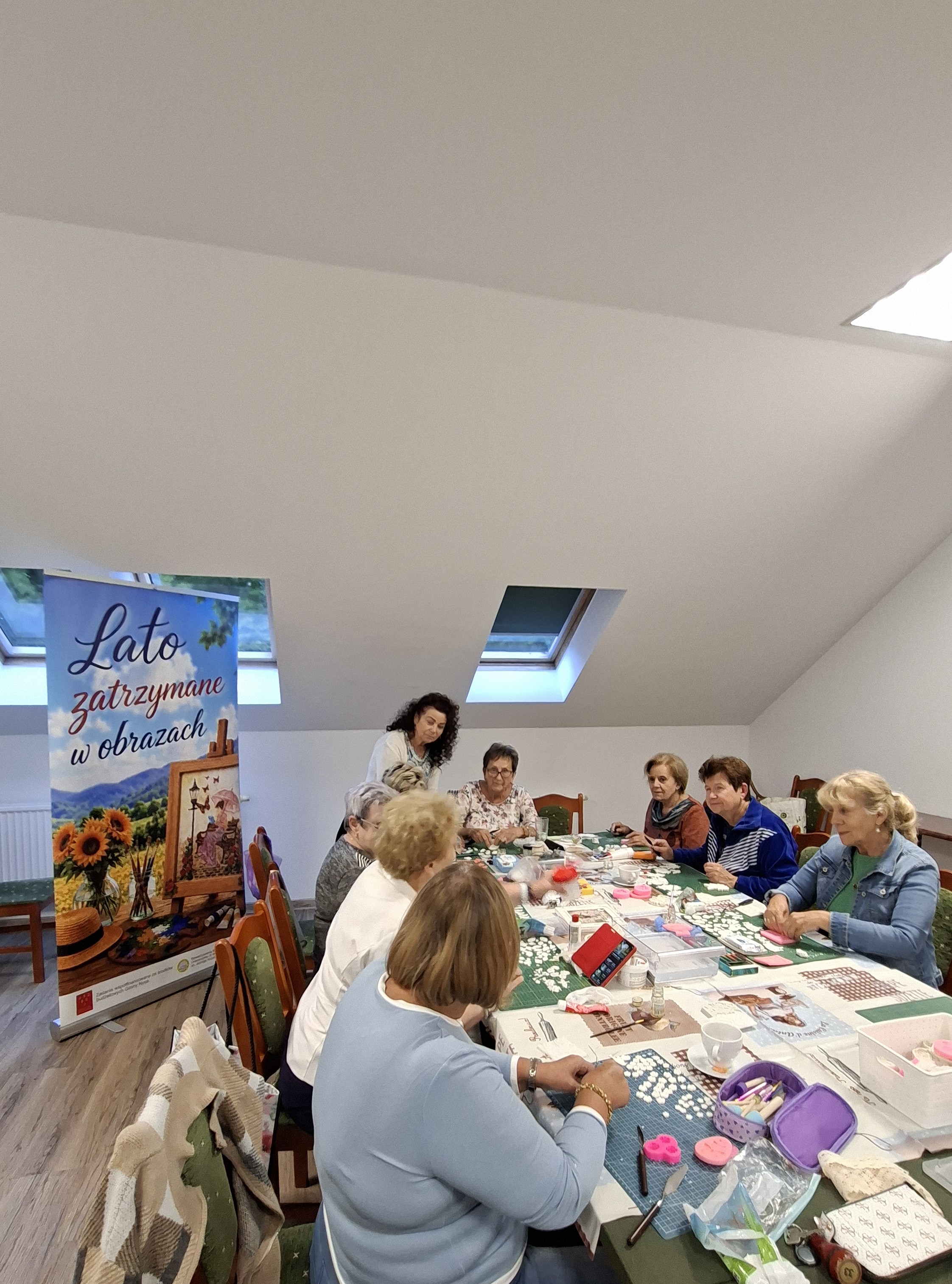 Uczestniczki warsztatów przygotowują ozdoby z masy modelującej przy wspólnym stole