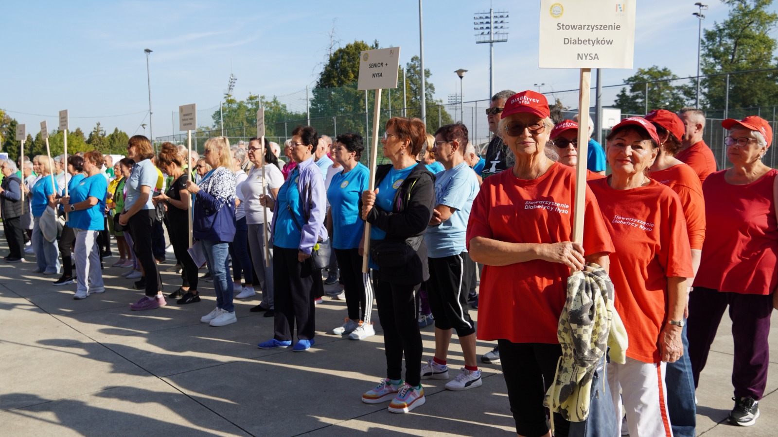 Uczestnicy spartakiady z tabliczkami klubów i stowarzyszeń